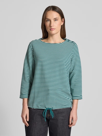 Vrouwenmodel draagt Regular Fit 3/4-Shirt uit biologische katoenmix van Tom Tailor, gestreept met all-over patroon, knopen bij hals, ronde hals, 3/4-mouwen, tunnelzoom, ribstructuur, vooraanzicht bovenlichaam.