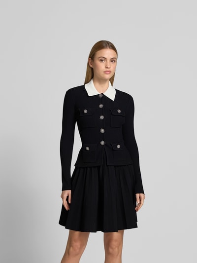 Frauenmodel trägt Minikleid aus Viskose-Mix von Self-Portrait in Schwarz mit Ziersteinbesatz, Strick-Optik, Slim Fit, Ganzkörperansicht von vorne.