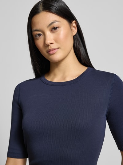 Vrouwenmodel draagt T-shirt met 1/2-arm model 'SELAY' van Drykorn, puur katoen, slim fit, ronde hals, ruglengte maat S 52 cm; nahaufnahme bovenlichaam.
