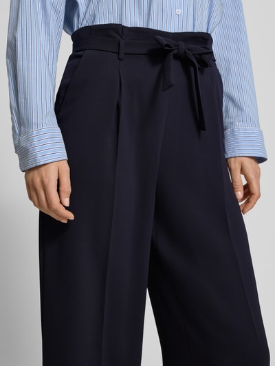 Frauenmodel trägt Regular Fit Stoffhose mit Gürtel von Windsor in Dunkelblau, Bügelfalten, Seitentaschen, Nahaufnahme Oberkörper.