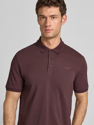 Männermodel trägt Regular Fit Poloshirt aus reiner Baumwolle Modell 'DONOS222' von HUGO, Optik: Unifarben, Nahaufnahme Oberkörper.