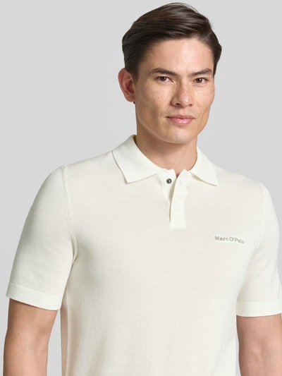 Männermodel trägt Regular Fit Poloshirt aus reiner Baumwolle Marc O'Polo × DFB Travel Collection in Unifarbe, Nahaufnahme Oberkörper.
