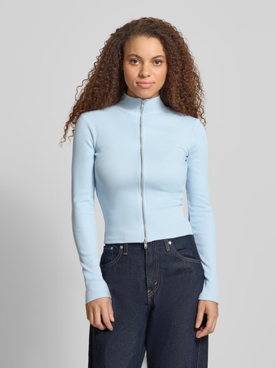 Frauenmodel trägt Slim Fit Jacke mit Stehkragen von Gina Tricot, hellblau, Baumwoll-Mix, Zweiwege-Reißverschluss, Ganzkörperansicht von vorne.