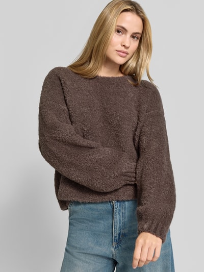 Frauenmodel trägt Pullover aus Leinen-Mix mit Alpaka-Anteil Modell 'Zolly' von American Vintage, braune Strick-Optik, Relaxed Fit, Nahaufnahme Oberkörper.