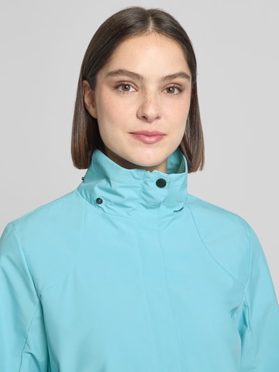 Frauenmodel trägt Parka mit Kapuze und verdecktem Reißverschluss von G.I.G.A. DX in Hellblau, glatte Textur, Nahaufnahme Oberkörper. Wassersäule 10.000mm, Kapuze mit Kordelstoppern, Label-Patch, Seitliche Reißverschlusstaschen, Rückenlänge 70 cm, Schulterbreite 41 cm, Brustweite 51 cm, Ärmellänge 63 cm bei Größe 36.