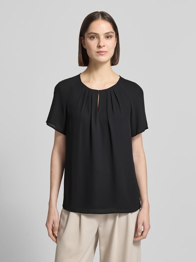 Frauenmodel trägt Blusenshirt mit Schmetterlingsärmeln und Schlüsselloch-Ausschnitt von Comma, Loose Fit, Raffung, Schwarz, Ganzkörperansicht von vorne. Rückenlänge bei Größe 36: 66 cm, Ärmellänge 16 cm.