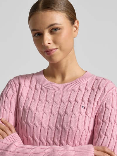 Modelka nosi Slim Fit Strickpullover aus reiner Baumwolle od Tommy Hilfiger, różowy, wzór w prążki, crew neck, logo, dzianina, bawełna; zbliżenie górnej części ciała.
