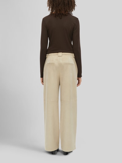 Männermodel trägt Weite Hose in Lederoptik von s.Oliver BLACK LABEL in Beige mit glatter Textur und weitem Bein, Ganzkörperansicht Rückansicht