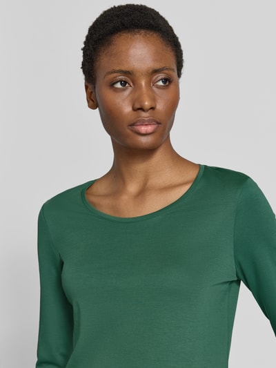 Frauenmodel trägt Shirt aus reiner Baumwolle von Christian Berg Woman in dunklem Grün, glatte Textur, Nahaufnahme Oberkörper. Gerader Schnitt, Rundhalsausschnitt, halbärmelig, Rückenlänge bei Größe 36: 59 cm.