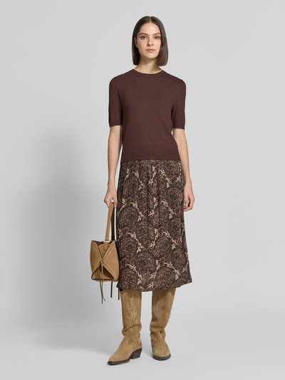 Frauenmodel trägt Plisseerock mit elastischem Bund Modell 'Ar44ianaa' von ZABAIONE, A-Linie, Midilänge, braune Muster, Chiffon, Ganzkörperansicht von vorne.