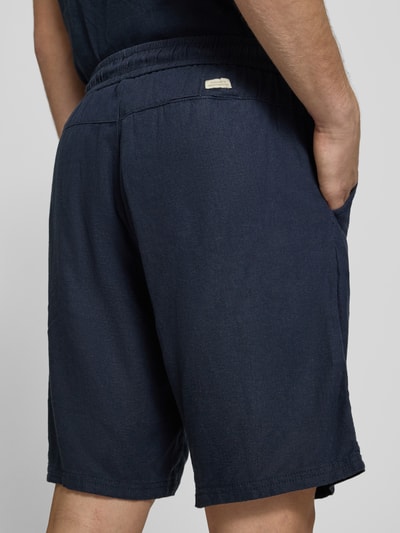 Männermodel trägt Shorts aus Leinen-Viskose-Mix Modell 'MALVIN' von Blend in Dunkelblau mit Elastikbund und Eingrifftaschen, Nahaufnahme Rückansicht, Herren Shorts Regular-Fit, Bundweite 37 cm, Innenbeinlänge 23 cm, Größe M.
