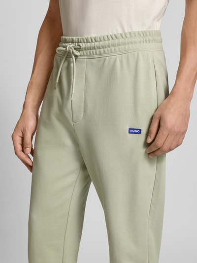 Männermodel trägt Relaxed Fit Sweatpants aus reiner Baumwolle Modell 'NAPIN` von HUGO BLUE, Optik: Unifarben, Label-Patch, Tunnelzug, Bundabschluss: elastisch, Beinabschluss: gerippt, seitliche Eingrifftaschen, Materialverarbeitung: Sweat, Ganzkörperansicht von vorne.