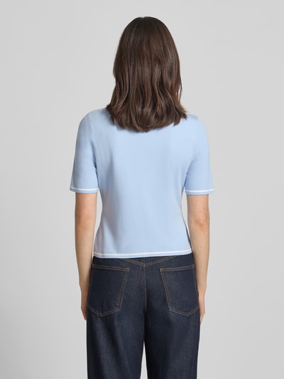 Frauenmodel trägt Strickshirt aus Viskose-Mix von Marc Cain in Hellblau, körpernahe Passform mit Rundhalsausschnitt und 1/2-Arm, Rückenlänge 48 cm, Ärmellänge 23 cm, Ganzkörperansicht Rückansicht.