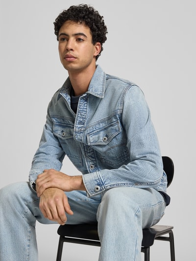 Männermodel trägt Jeansjacke mit Knopfleiste und Brusttaschen Modell 'Dakota' von G-Star Raw in Reine Baumwolle, Regular-Fit, Nahaufnahme Oberkörper.