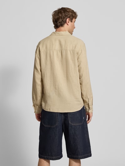 Männermodel trägt Slim Fit Freizeithemd aus Leinen-Baumwoll-Mix Modell 'NELSON' von Redefined Rebel, Beige, Struktur, Ganzkörperansicht Rückansicht, Herren, Kentkragen, Brusttasche, Label-Detail, Rückenlänge 50 cm, Schulterbreite 49 cm, Ärmellänge 72 cm, Größe M.