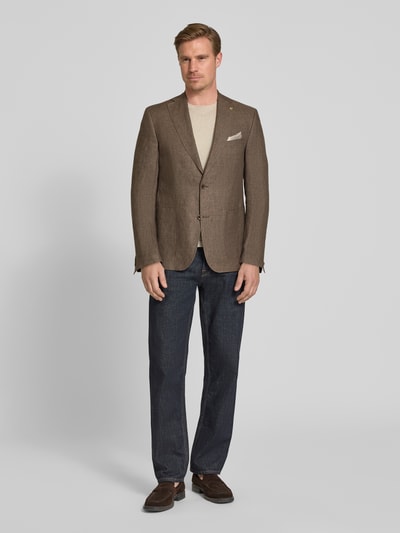 Männermodel trägt Regular Fit Sakko aus Leinen-Mix Modell 'Tebbo' von Carl Gross in Braun mit Reverskragen, Ganzkörperansicht von vorne.