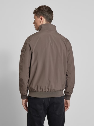 Männermodel trägt windbreaker met materiaalmix met stretch, recht model, opstaande kraag, ritssluiting, ritszak op de mouw, elastische boorden, model 'YETUR' van CARS JEANS, ruglengte maat M 71 cm, schouderbreedte 44 cm, borstwijdte 50 cm, mouwlengte 68 cm, geheel in bruintint, gladde textuur, geheel zichtbare rug, Ganzkörperansicht Rückansicht.