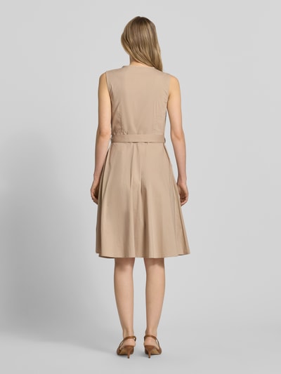 Frauenmodel trägt Kleid mit V-Ausschnitt in Wickel-Optik von More & More, Baumwoll-Mix, Tailliert, Ärmelloses-Design, Taillenband, Rückenlänge 100 cm, Brustweite 35 cm, Ganzkörperansicht Rückansicht.