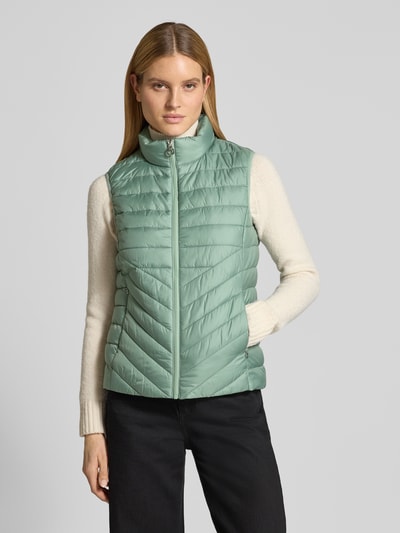 Vrouwenmodel draagt Regular Fit Bodywarmer met ritssluitzakken van s.Oliver RED LABEL, effen look, opstaande kraag, voorkant bovenlichaam.