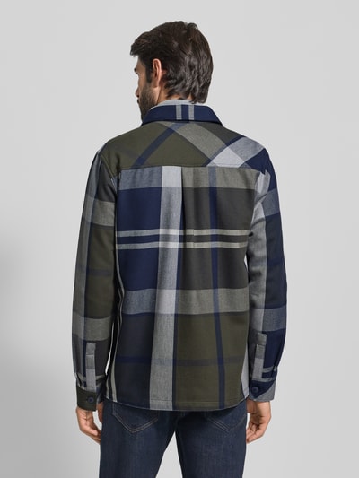Männermodel trägt Oversized Hemdjacke aus reiner Baumwolle von Barbour, Optik: unifarben, Gitterkaro, Label-Stitching, Ganzkörperansicht Rückansicht.
