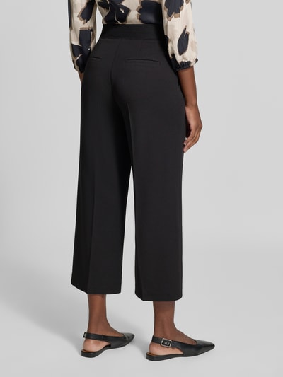 Frauenmodel trägt Regular Fit Weite Hose mit Bügelfalten Modell 'LT JULI' von Betty Barclay in Schwarz, Ganzkörperansicht Rückansicht, Damen Weite Hose von Betty Barclay.