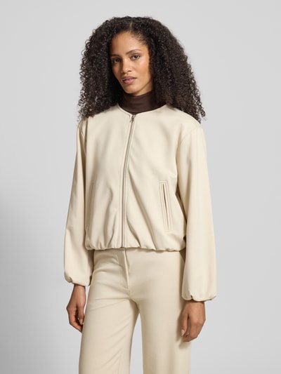 Vrouwenmodel draagt Regular fit damesjack met elastische materiaalmix met viscose van FREE/QUENT, model 'Nanni', ronde hals, ritssluiting, steekzakken, ballonlook, kleur beige, gladde textuur. Ganzkörperansicht von voren.