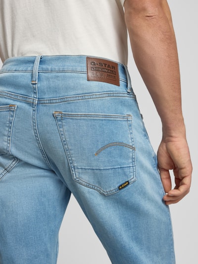 Männermodel trägt Slim Fit Jeans im Used-Look Modell '3301' von G-Star Raw, hellblauer Baumwoll-Mix mit Stretch-Anteil, Detailaufnahme Rückansicht.