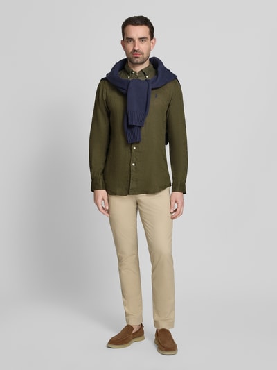 Männermodel trägt Regular Fit Freizeithemd aus reinem Leinen von Polo Ralph Lauren in Optik: Unifarben mit Button-Down-Kragen, Ganzkörperansicht von vorne.