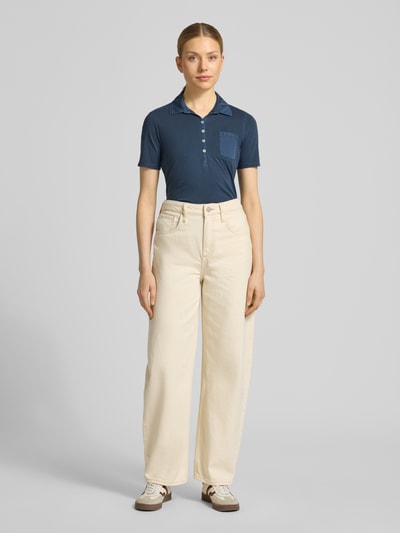 Kobiece modelka nosi Regular Fit Poloshirt aus reiner Baumwolle von Marc O'Polo, efekt: jednolity kolor, krój regular fit, aplikacja: nadruk z logo, kształt kołnierza: kołnierzyk polo, zapięcie: krótka listwa guzikowa, rękaw: krótki rękaw, brustasza, wykończenie materiału: dżersej, materiał: czysta bawełna, pełny widok z przodu.