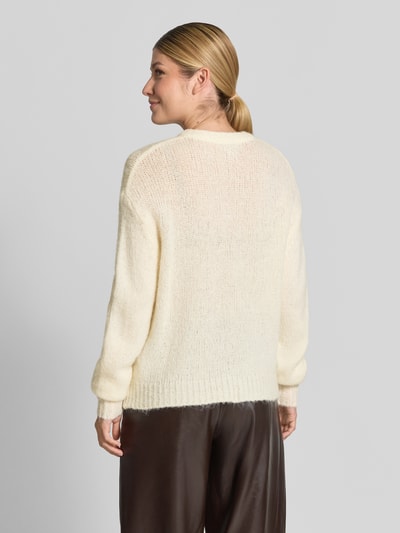 Frauenmodel trägt Cardigan mit Alpaka-Anteil und Rundhalsausschnitt Modell 'OTIA' von b.young in Creme, lockere Strickstruktur, Ganzkörperansicht Rückansicht.