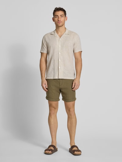 Männermodel trägt Leinenshorts mit Bindegürtel und Gesäßtaschen von MCNEAL in Oliv, Reines Leinen, Straight Fit, Ganzkörperansicht von vorne.