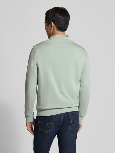 Męski model nosi Regular Fit Sweatshirt aus Baumwoll-Mix od Tom Tailor, jednokolorowy, nadruk z logo, dzianina dresowa, mieszanka bawełny, całopostaciowy widok z tyłu.