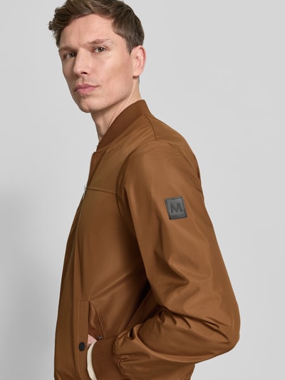 Männermodel trägt Jacke mit Stehkragen Modell 'clay' von Matinique in bruin, regular fit, steekzakken met drukknoopsluiting, ritssluiting, ganzkörperansicht von vorne