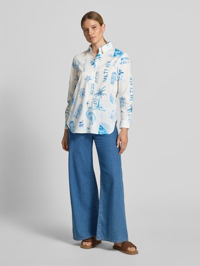 Frauenmodel trägt Regular Fit Bluse im Allover-Look von Oui aus reiner Baumwolle, weiß-blau gemustert, Hemdblusenkragen, Ganzkörperansicht von vorne.