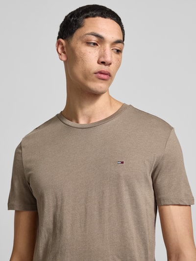 Männermodel trägt Slim Fit T-Shirt aus Baumwoll-Mix Modell 'JASPE HERITAGE' von Tommy Jeans, Melange-Optik, Logo-Stitching, Nahaufnahme Oberkörper.