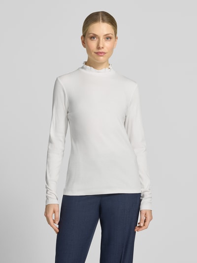 Kobiece model nosi Slim Fit Longsleeve aus Baumwoll-Mix od MORE, elastyczna mieszanka bawełny, krój slim fit, stójka, fakturowany wzór, długość tyłu w rozmiarze 36: 58 cm, widok całej sylwetki z przodu.