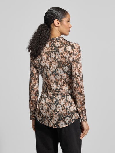 Modelka nosi Regular Fit Bluzę w Allover-Look model 'CLOUIS SHIRT' od Guess z kołnierzem koszulowym, zapięciem na guziki, długość tyłu 69 cm, długość rękawa 59 cm, odcienie brązu i beżu, całość w abstrakcyjne wzory, krój regular fit, widok całej sylwetki z tyłu.