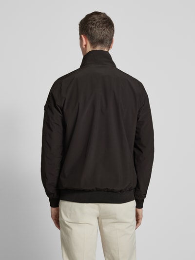Männermodel trägt schwarzen Windbreaker mit Stehkragen Modell 'YETUR' von CARS JEANS, glatte Struktur, Ganzkörperansicht Rückansicht.