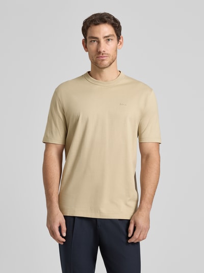 Mężczyzna nosi Regular Fit T-Shirt aus reiner Baumwolle Modell 'H-TAUT 15' von BOSS, beżowy, gładki, krótki rękaw, okrągły dekolt, Ganzkörperansicht von vorne.