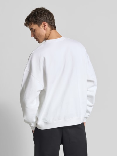 Männermodel trägt Relaxed Fit Sweatshirt aus reiner bawełna von Dsquared2, kolor biały, detal z logo, stójka, elastyczne wykończenia, długość tyłu w rozmiarze M: 67 cm, Ganzkörperansicht Rückansicht