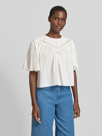 Kobiece modelka nosi Relaxed Fit Blusenshirt aus reiner Baumwolle Modell 'C_BENZY' od BOSS Orange, biała bluzka z krótkimi motylkowymi rękawami, koronkowe wstawki i marszczenia, okrągły dekolt, czysta bawełna, zdjęcie całej sylwetki z przodu.