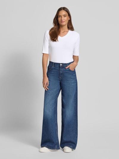 Frauenmodel trägt weißes T-Shirt mit V-Ausschnitt von Christian Berg Woman, Baumwoll-Elasthan-Mix, Regular Fit, Ganzkörperansicht von vorne.