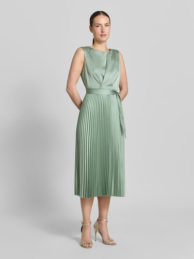 Modelka kobieca ma na sobie Midikleid mit Plisseefalten und Bindegürtel od comma, miętowa zieleń, materiał elastyczny, A-linia, plisowana struktura, pasek, długość tyłu w rozmiarze 36: 35 cm, szerokość w rozmiarze 36: 40 cm, całopostaciowy widok z przodu.