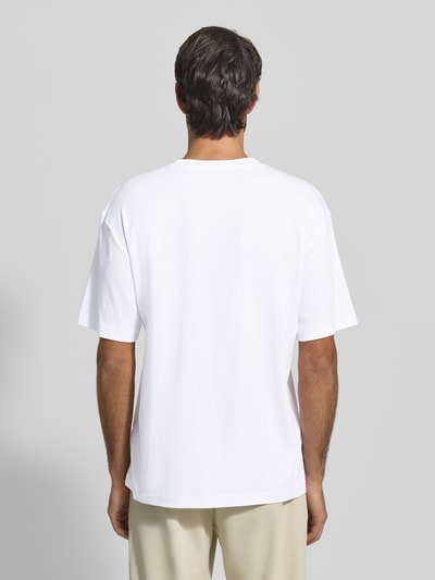 Męski model nosi Relaxed Fit T-Shirt aus reiner Baumwolle Modell 'JOIN' od BOSS Green, biały, krój luźny, widok całej sylwetki z tyłu.
