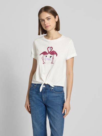 Frauenmodel trägt Regular Fit T-Shirt aus reiner Baumwolle Modell 'DORA LIFE' von Only, unifarben, Pailletten, Knotendetail, Ganzkörperansicht von vorne.