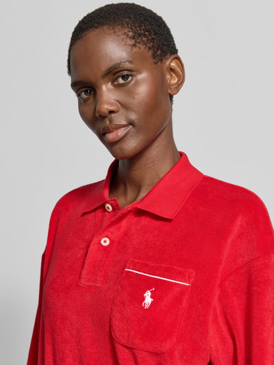 Frauenmodel trägt Regular Fit Poloshirt aus Baumwoll-Mix von Polo Ralph Lauren in Rot, Optik: Unifarben, Logo-Stitching, Kontrastpaspel, Polokragen, Langarm, Materialverarbeitung: Frottee, Nahaufnahme Oberkörper.