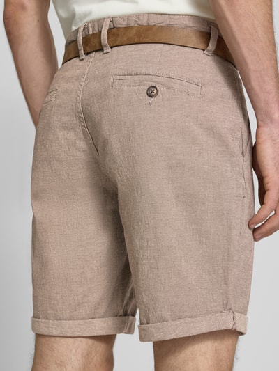 Männermodel trägt Bermudas mit Gürtel und Eingrifftaschen Modell 'NEBRASKA' von Redefined Rebel in Beige, Baumwoll-Mix mit Stretch-Anteil, Ganzkörperansicht Rückansicht, Herren Bermudas, Knopf- und Reißverschluss, Gürtel mit Dornschließe, Französische Eingrifftaschen, Gesäßleistentaschen, Bundweite bei Größe L 46 cm, Innenbeinlänge bei Größe L 21 cm.
