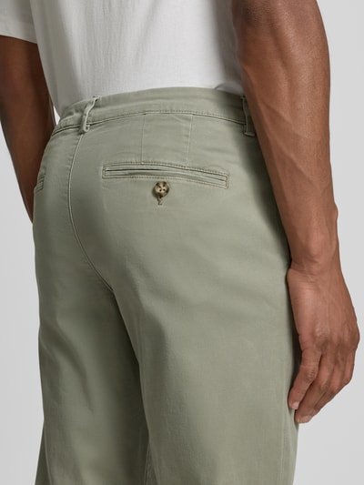 Mannenmodel draagt Slim Fit Chino uit katoenmix model 'MILES' van Selected Homme in effen kleuren met steekzakken, achterzak, detailopname rugaanzicht.