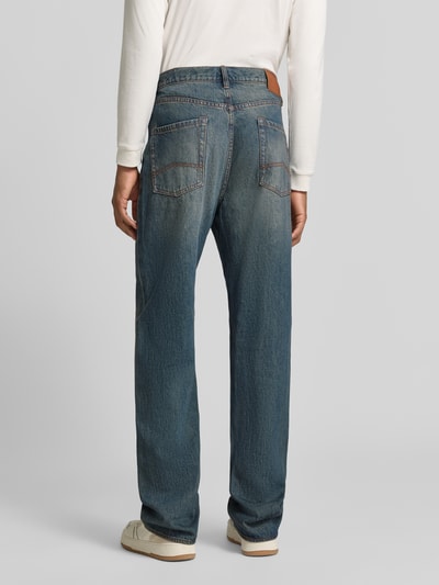 Männermodel trägt Jeans im 5-Pocket-Design von Armani Exchange in Blau, Used-Look, Straight Fit, reine Baumwolle, Ganzkörperansicht Rückansicht.