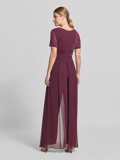 Frauenmodel trägt Regular Fit Jumpsuit aus Mesh von Vera Mont in Dunkelrot mit transparenten Details, fließende Textur, Ganzkörperansicht Rückansicht.
